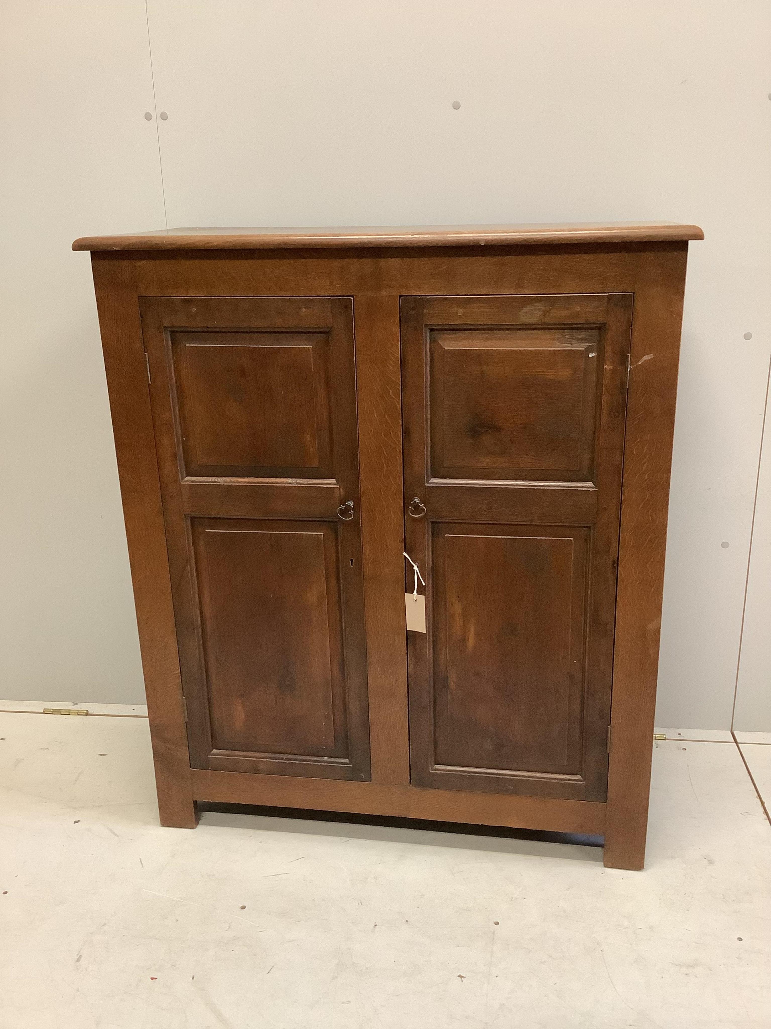 An early 20th century panelled oak two door cupboard, width 96cm, depth 42cm, height 112cm. Condition - fair, top faded, ring and spot stained.